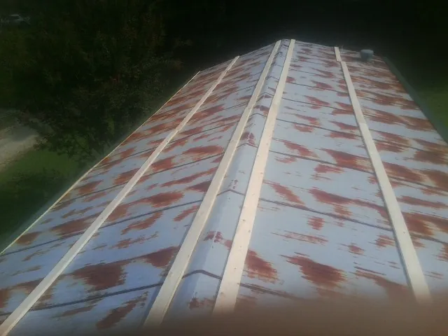Rusted metal roof panels with new wood purlins before replacement — Storm Damage Roof Repair in Bessie by Roofing Brothers