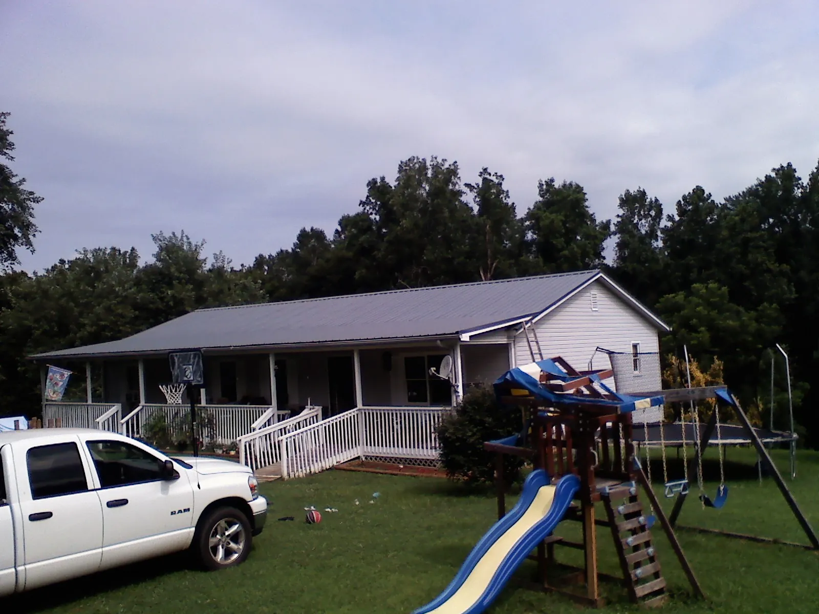 Dark metal roof on a country home with a full length front porch in Bessie
