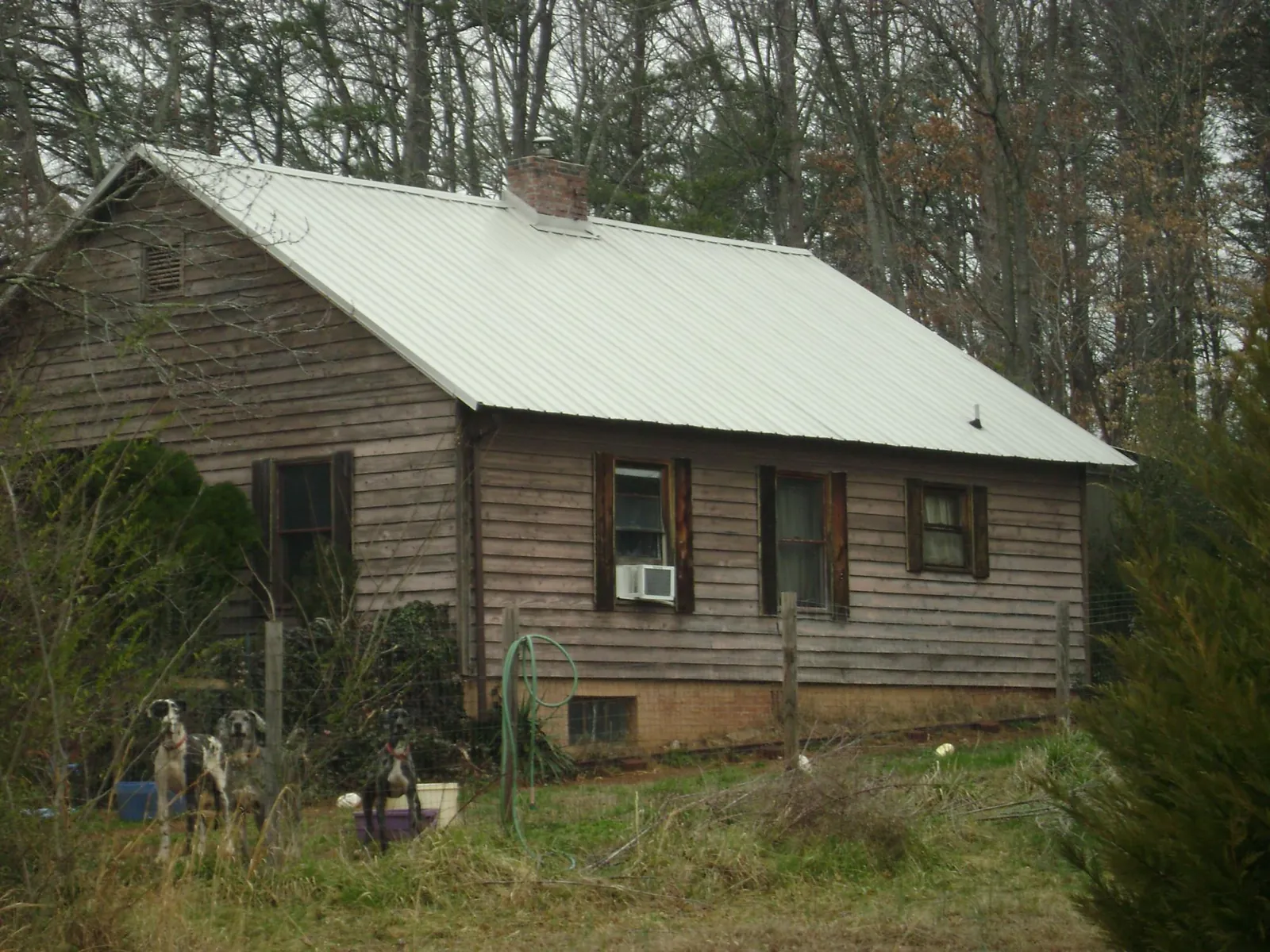 White metal roof on an old wood sided farmhouse, from a Metal Roof Installation job in Bessie